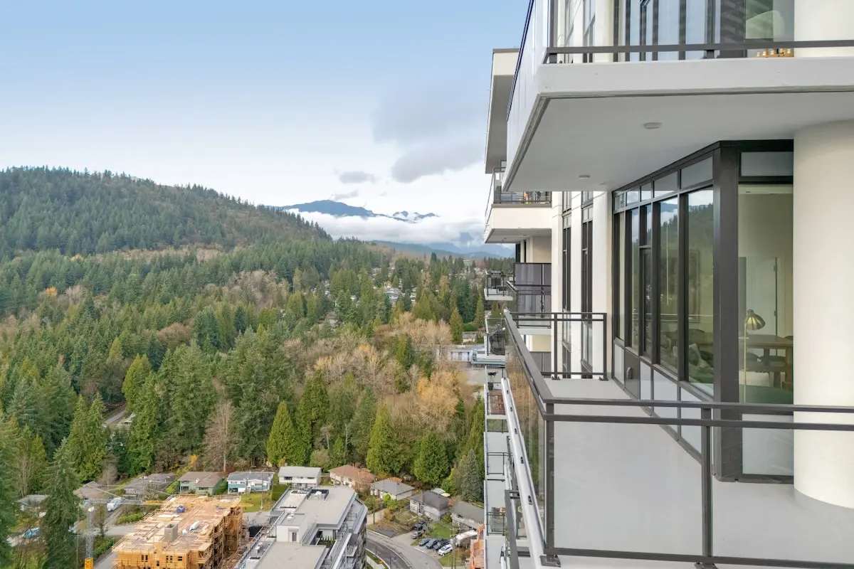 Burnaby hillside, forest, and mountains beside a residential tower