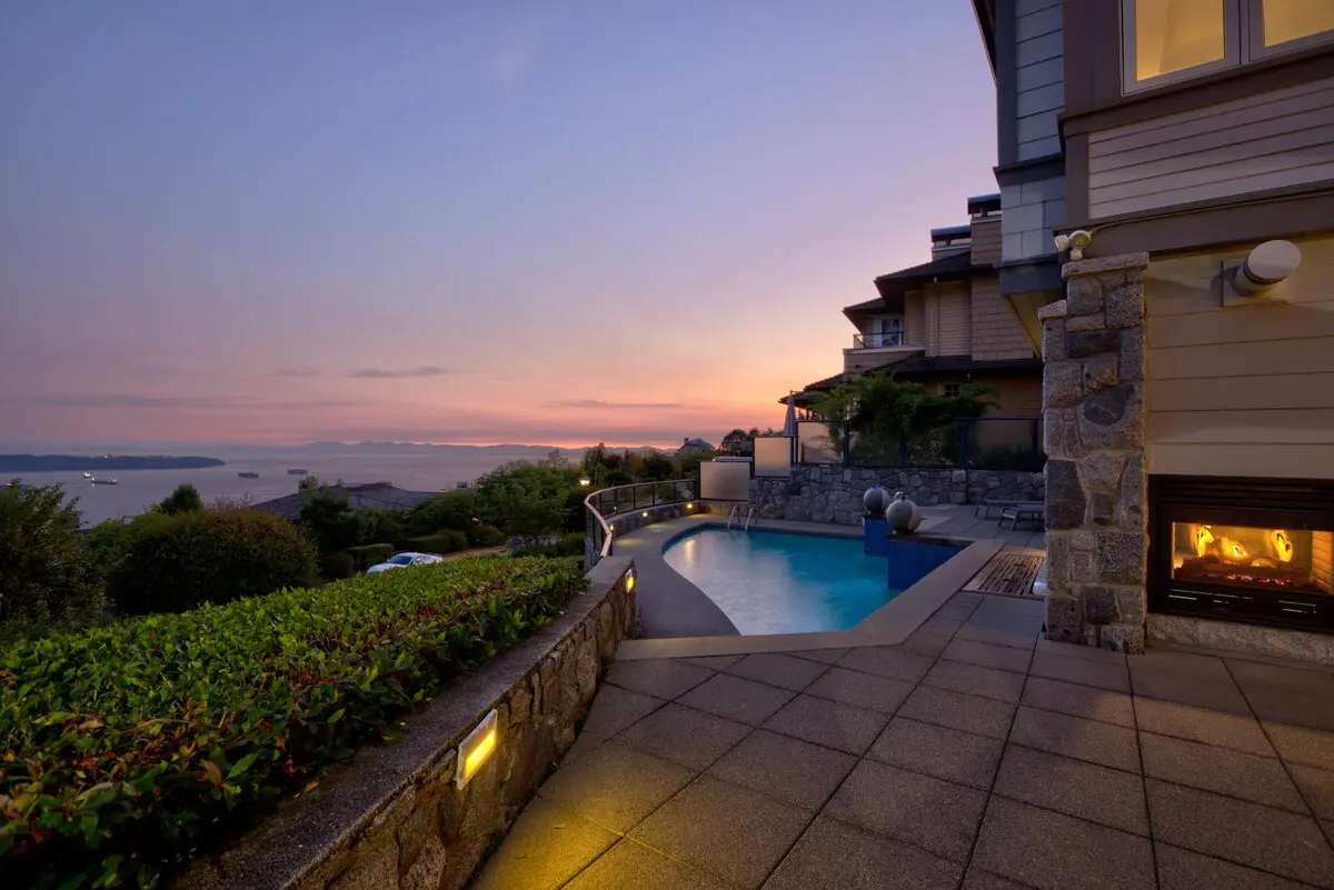 West Vancouver hillside home, pool, and ocean at dusk
